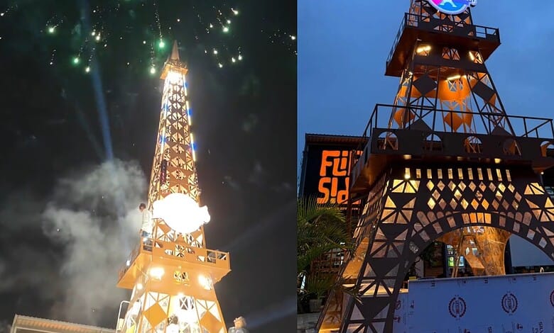 Illuminated replica of the Eiffel Tower in Hyderabad during night with fireworks.