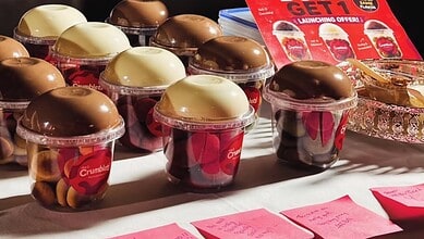 Assorted desserts in cups with chocolate and vanilla toppings at Sainikpuri street stall.