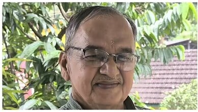 Portrait of Girish Bharadwaj smiling outdoors with greenery in the background.