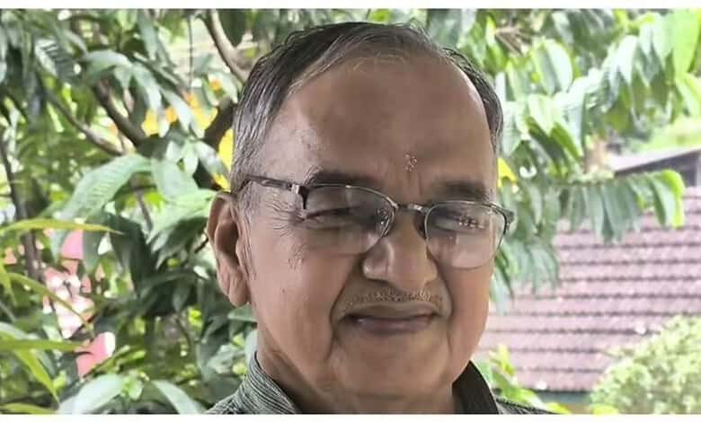 Portrait of Girish Bharadwaj smiling outdoors with greenery in the background.