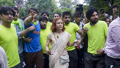 Prominent woman in white saree leading a march with young supporters at Jantar Mantar.