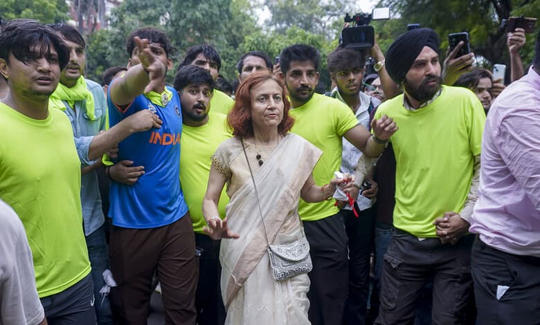 Prominent woman in white saree leading a march with young supporters at Jantar Mantar.