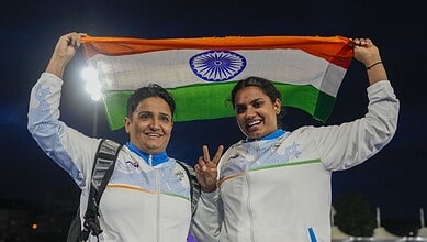 Two Indian para athletes holding the Indian flag after winning gold at the Commonwealth Games.