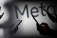 Silhouettes of hands and smartphones against a blurred background with 'Meta' text.