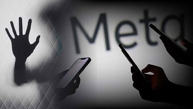 Silhouettes of hands and smartphones against a blurred background with 'Meta' text.