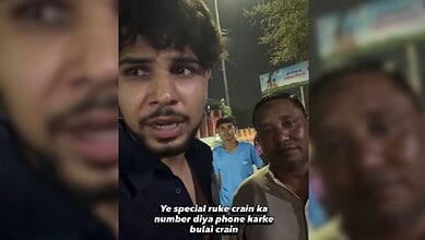 Young man speaking to camera during night, with two men in background, in a public setting.