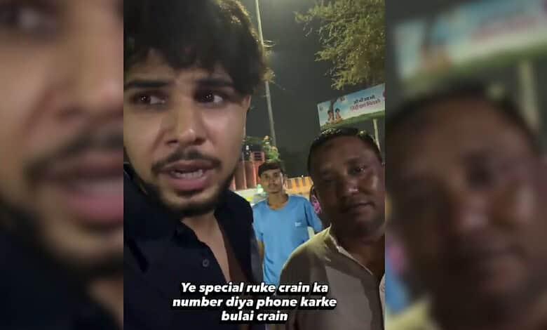Young man speaking to camera during night, with two men in background, in a public setting.