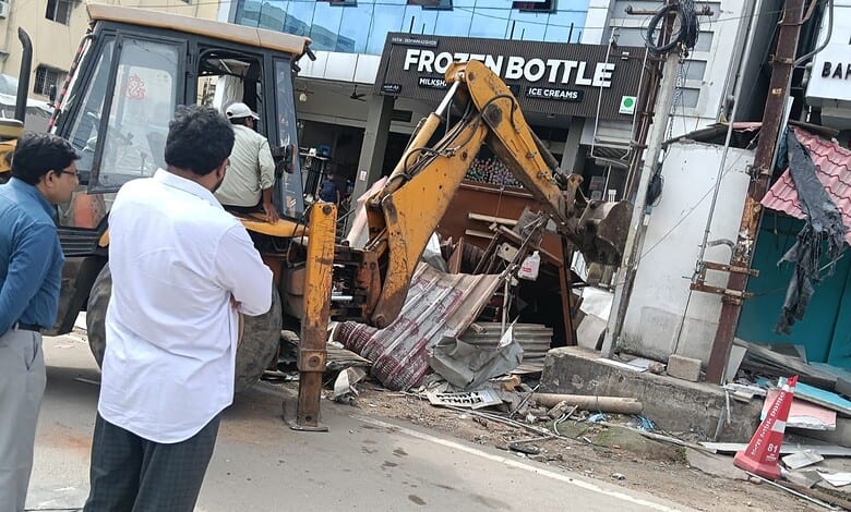 Construction machinery demolishing encroached structures on Hyderabad's DLF food street.
