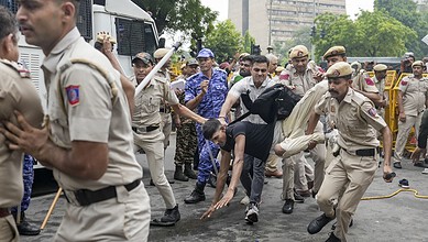Police officers and civilians clash during a protest on a city street.