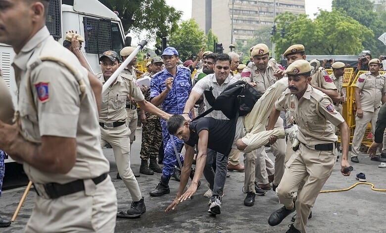 Police officers and civilians clash during a protest on a city street.
