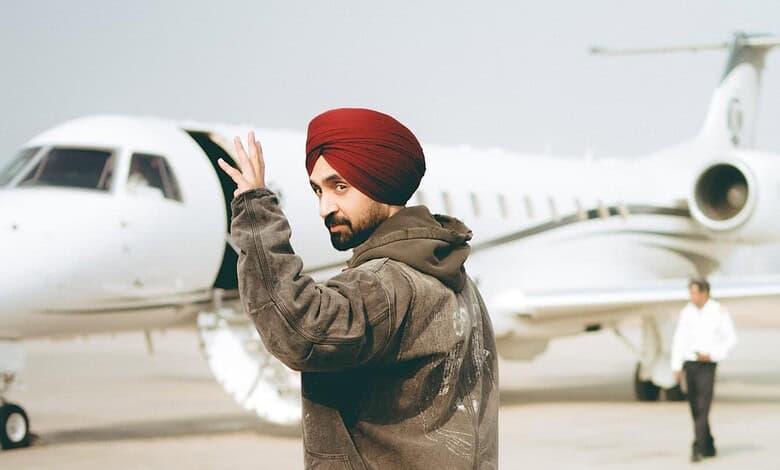 Man wearing a red turban and brown jacket waving near a private jet at an airport.