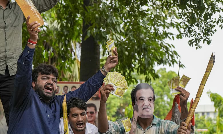 Protesters holding Indian currency notes and bamboo sticks during IYC protest against 'ganne ka juice'.