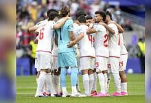 Iranian football team huddles during a match at FIFA World Cup, showing team unity.