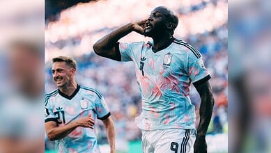 Argentinian footballer celebrating during a match, wearing light blue and white jersey with number 7.