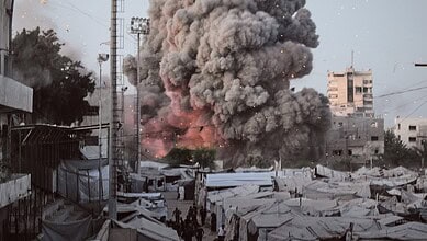 Explosion with thick black smoke rising over a cityscape with tents and buildings.