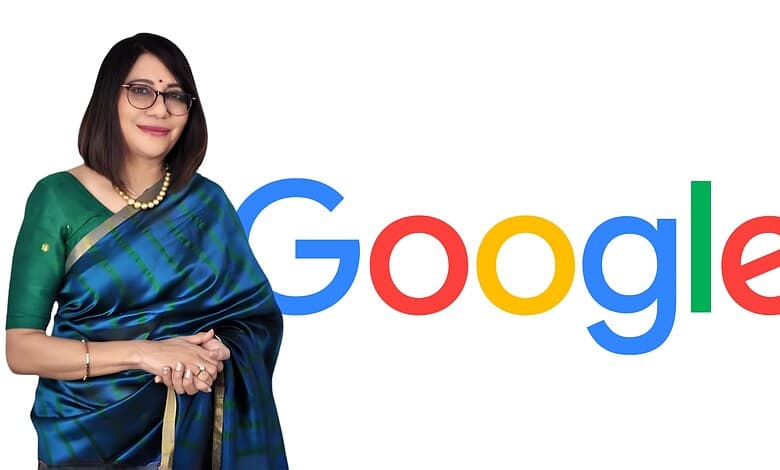 Indian woman in green saree standing next to Google logo, smiling at camera.