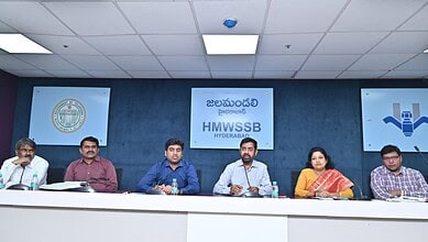 HMWSSB officials seated at a press conference in Hyderabad with banners in Telugu and English behind them.