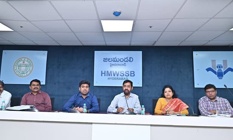 HMWSSB officials seated at a press conference in Hyderabad with banners in Telugu and English behind them.