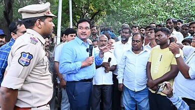Community meeting with police officer and residents in Hyderabad, discussing housing issues.