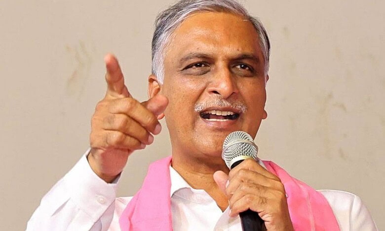 Harish Rao addressing a crowd with a microphone, gesturing with his hand.