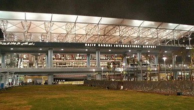 Rajiv Gandhi International Airport at night with illuminated exterior and signage.