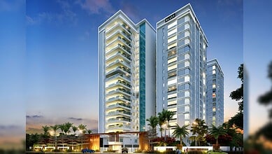 Modern 17-floor Hyderabad residential building with glass facade and palm trees in front.