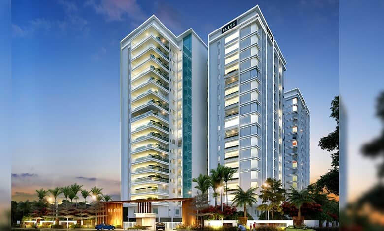 Modern 17-floor Hyderabad residential building with glass facade and palm trees in front.