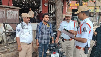 Hyderabad Traffic Police inspecting a bike with a fake number plate.