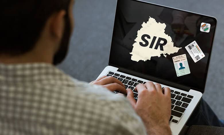 Person using laptop with SIR map and ID cards, highlighting online form issues.
