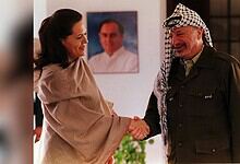 Sonia Gandhi and a Palestinian man shaking hands in a warm greeting.
