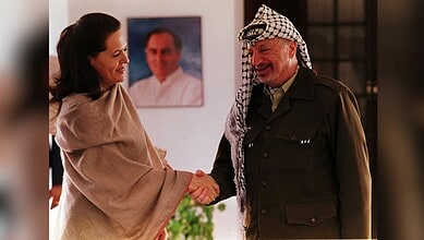 Sonia Gandhi and a Palestinian man shaking hands in a warm greeting.