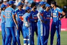 Indian cricket team players in blue uniforms during a match on the field.