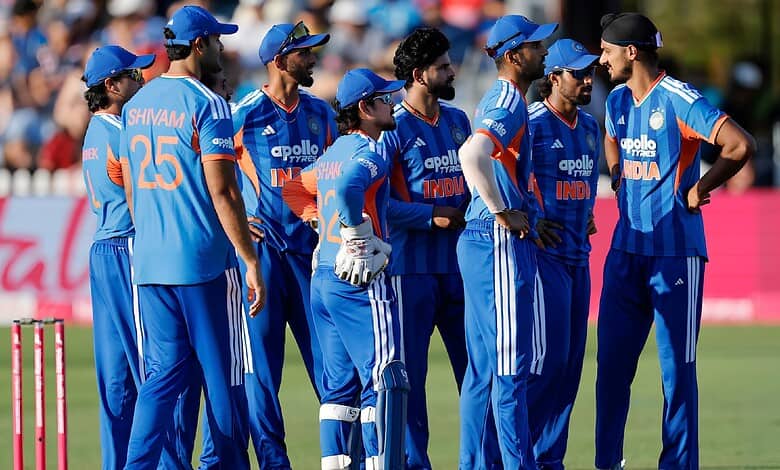 Indian cricket team players in blue uniforms during a match on the field.