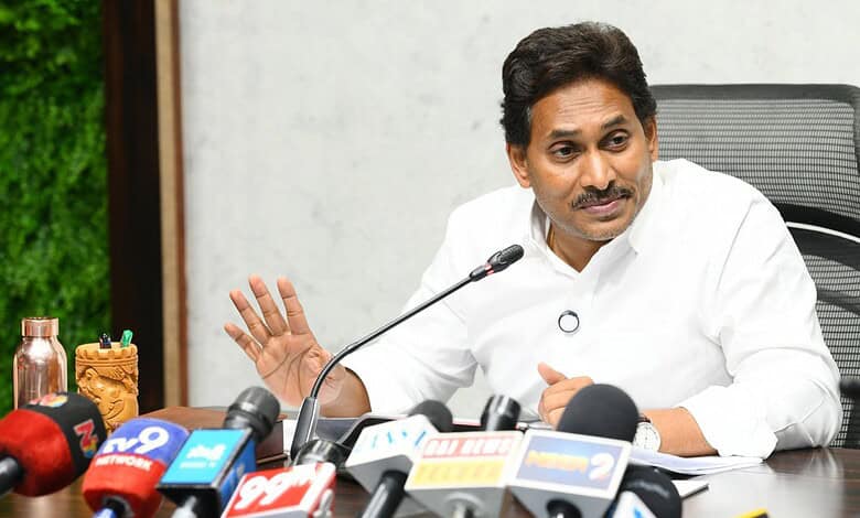 Indian politician addressing media at press conference with microphones and journalists present.