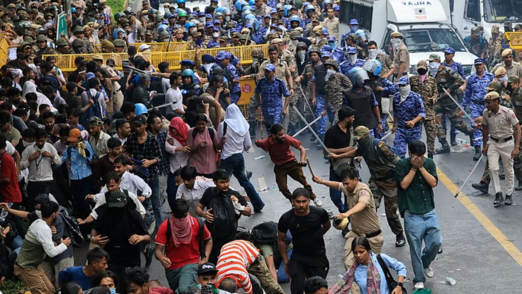 Protesters clash with police during NEET protest, police use force to control crowd.