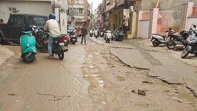Damaged road on Joshi Wadi with potholes and uneven surface in Hyderabad.