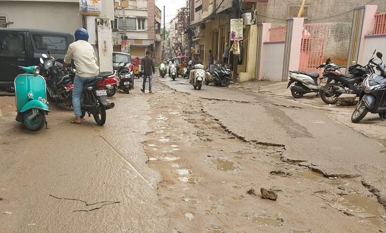 Damaged road on Joshi Wadi with potholes and uneven surface in Hyderabad.