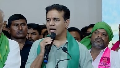 KTR speaking into a microphone at a political rally with supporters around him.