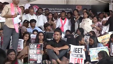 KTR addresses Gen-Z protesters during a rally, surrounded by diverse young demonstrators holding signs.