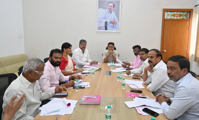 Group of men and women in a meeting room with documents and water bottles on the table.