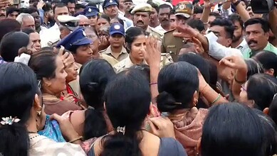 Protesters and police clash during Kalaburagi demolition protest, crowd gathered closely.