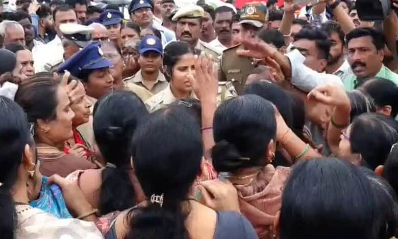 Protesters and police clash during Kalaburagi demolition protest, crowd gathered closely.