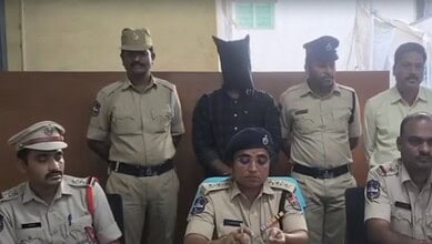 Karimnagar Police officers with a suspect in custody during a press conference.