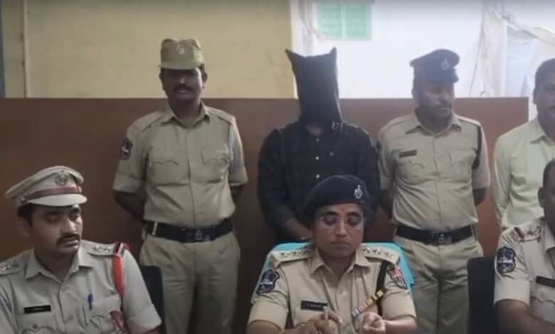 Karimnagar Police officers with a suspect in custody during a press conference.