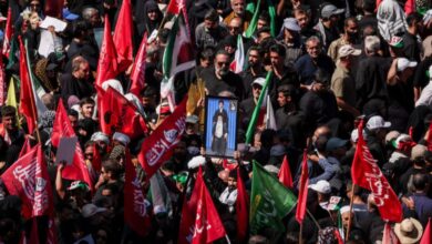 A man raises a picture featuring Iran's Supreme Leader Mojtaba Khamenei and Iran’s late Supreme Leader Ayatollah Ali Khamenei, as mourners gather on the day of the burial of Ayatollah Ali Khamenei, who was killed on February 28 in Israeli and U.S. airstrikes, in Mashhad, Iran, July 9, 2026. REUTERS/Alkis Konstantinidis