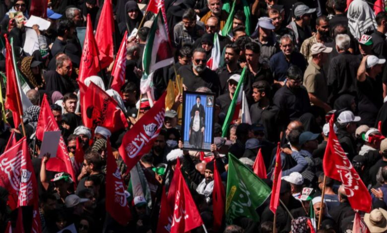 A man raises a picture featuring Iran's Supreme Leader Mojtaba Khamenei and Iran’s late Supreme Leader Ayatollah Ali Khamenei, as mourners gather on the day of the burial of Ayatollah Ali Khamenei, who was killed on February 28 in Israeli and U.S. airstrikes, in Mashhad, Iran, July 9, 2026. REUTERS/Alkis Konstantinidis