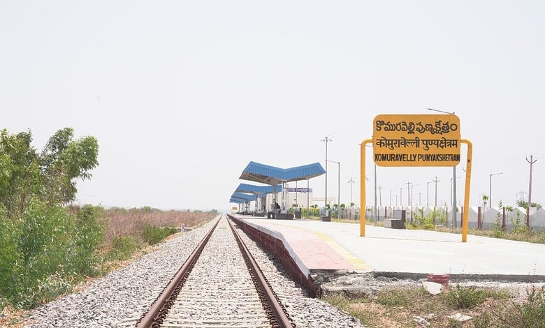 Komuravelli railway station platform with signboard and tracks in rural setting.