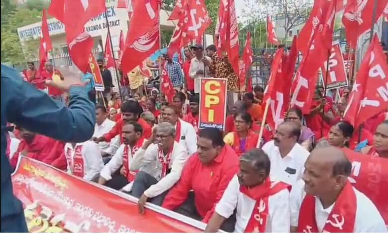 Left parties protest in Hanamkonda against hut demolitions with red flags and banners.