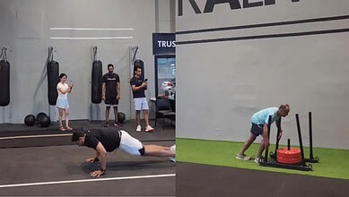 People working out in a gym with punching bags and a woman doing push-ups.