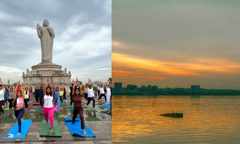 People practicing yoga at Hussain Sagar Lake on Friendship Day with Hyderabad skyline in background.